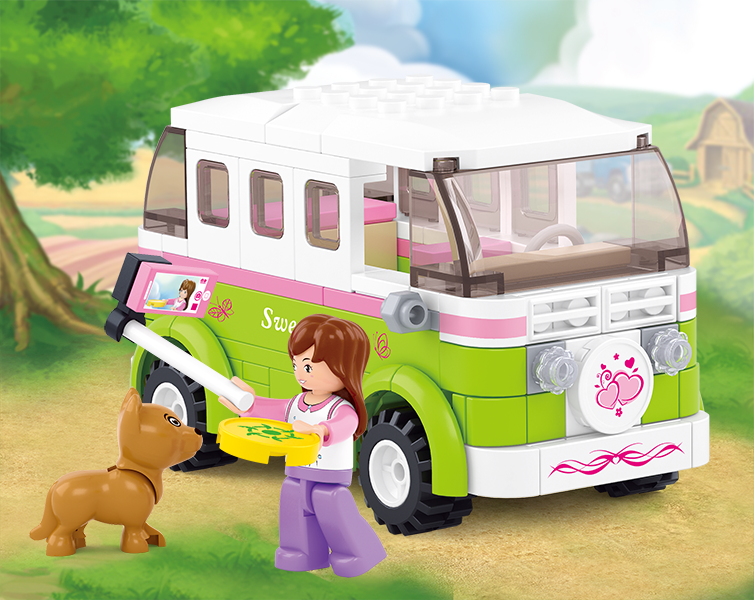 A box of Sluban building blocks from the "Girl's Dream" series featuring a girl with a brown dog, a green and white camper van, and 179 pieces. The set is for ages 6 and up.